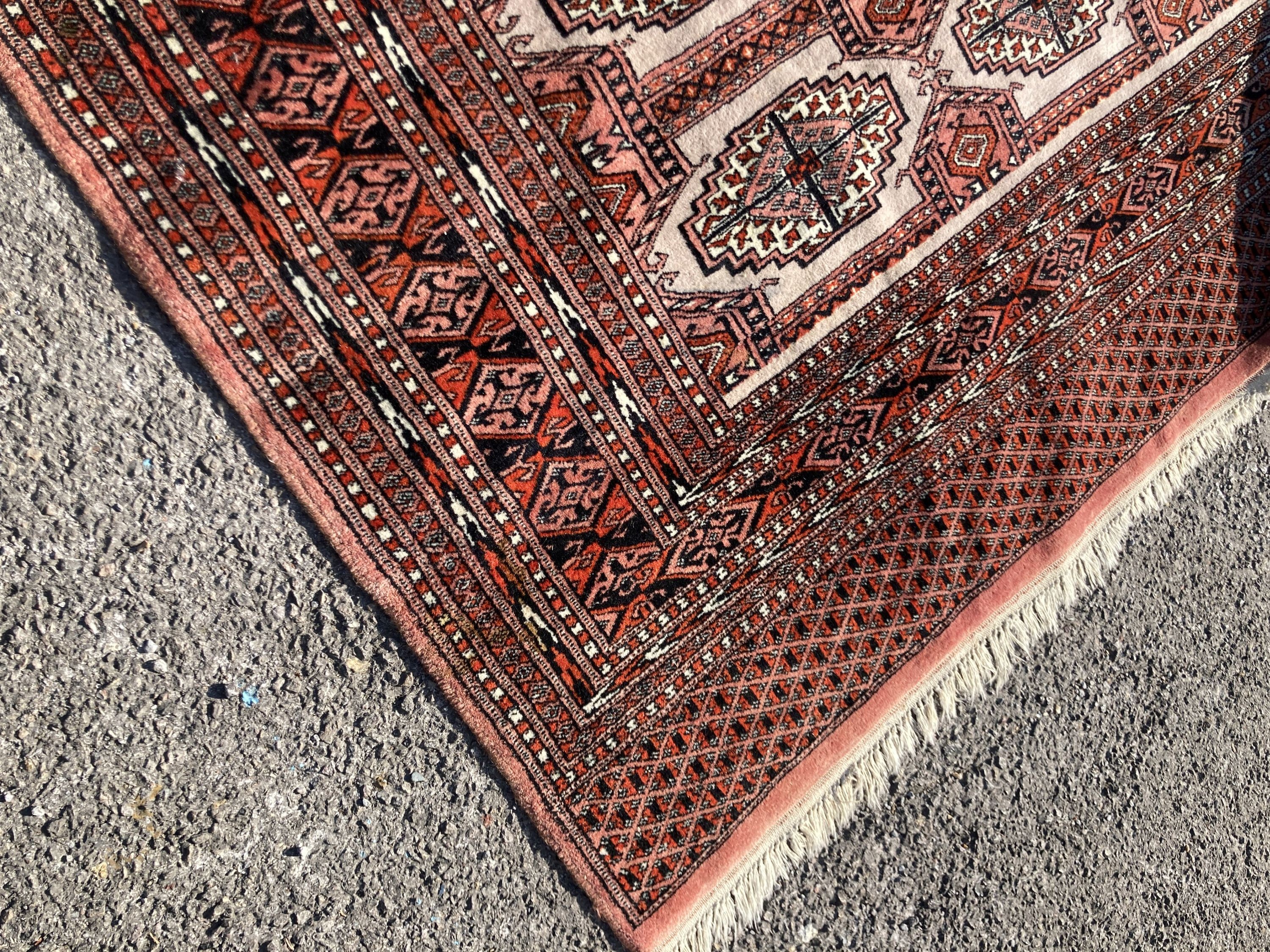 A pale red ground Tekke rug with signed border, 260 x 162cm